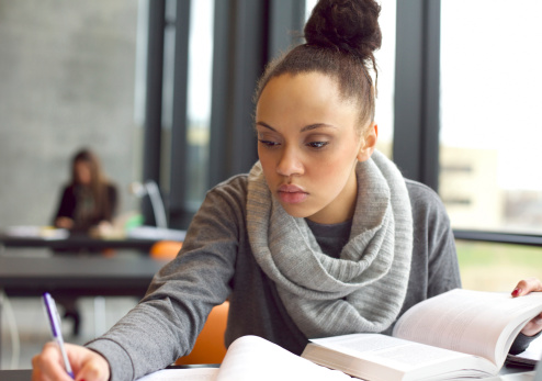 woman taking notes from a book